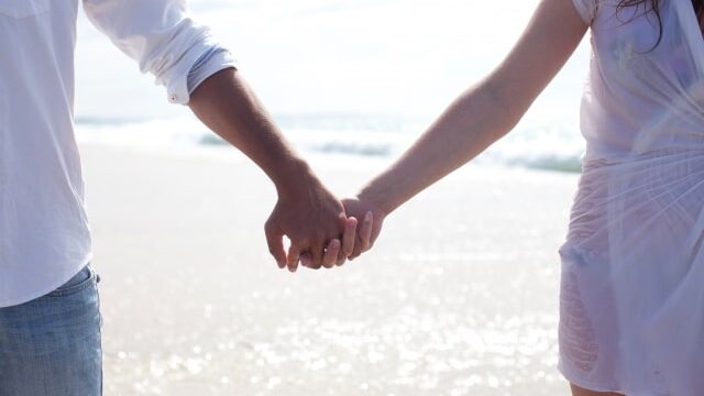 手をつないで歩く男女