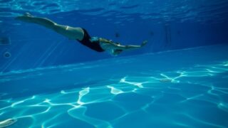 プールに潜り込む女性