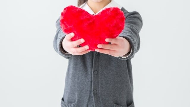 ハートマークを掲げる女性