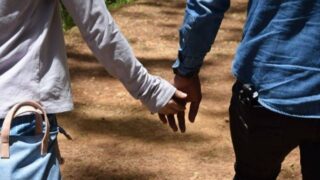 手をつないで歩いている男女