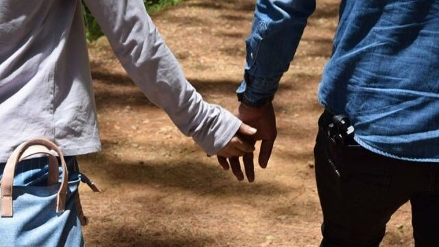 手をつないで歩いている男女